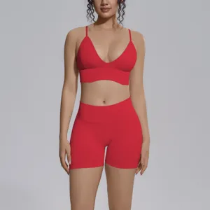 Detalle de conjunto de yoga rojo sin costuras, con sujetador deportivo y short alto.