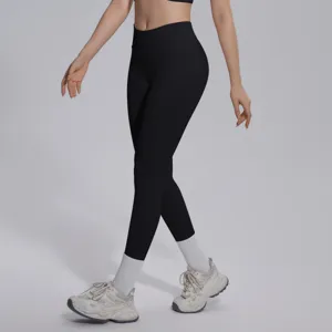 Detail shot of seamless high waist black yoga pants, showing fit, fabric texture and styling.