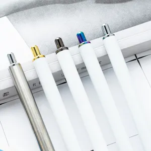 Set of press ballpoint pens with white barrels and metallic colorful push buttons for office.
