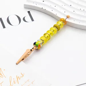 DIY beaded memo clip with vibrant yellow glass beads and metal alligator clamp for desk decor.