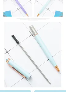 Detailopname van metalen balpencomponenten met een kristallen diamanttop en gouden afwerking.