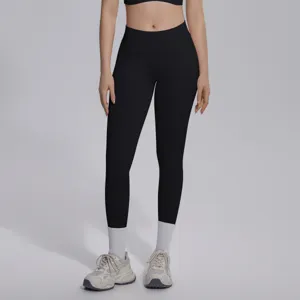 Detail view of seamless high-waist black yoga pants worn by model, showing fit and breathable fabric.