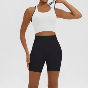 Close-up detail of women's athletic yoga set featuring a white sports bra and black shorts.