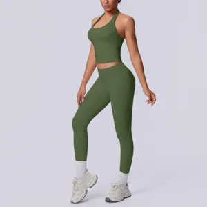Set fitness verde oliva con top corto halter senza cuciture e leggings a vita alta in studio.