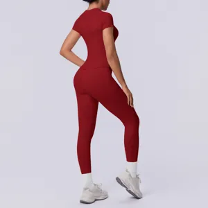 Naadloze gebreide yogaset in effen rood, korte mouw top en aansluitende sportlegging voor dames.