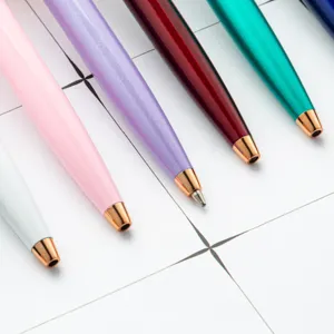 Bunte Metall-Kugelschreiber Set mit eleganten Roségold-Spitzen auf weißem Gitterhintergrund