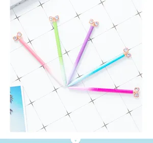 Colorful gradient crystal bow ballpoint pens showcase sparkling diamond top and smooth metal barrel.