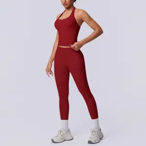 Dettaglio top halter senza cuciture e leggings, set sportivo rosso scuro in primo piano.