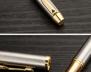 Vue de detail en gros plan du stylo bille metallique avec clip dore de luxe et corps argente.