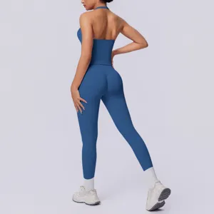 Set fitness senza cuciture blu con top halter schiena scoperta e leggings da yoga aderenti.