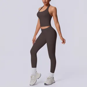 Dettaglio del top fitness halter marrone scuro senza cuciture e leggings a vita alta.