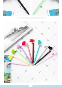 Detail view of vibrant colorful ballpoint pens with charming fabric flower charms on white grid.