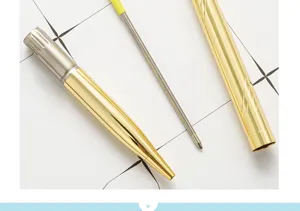 Close-up detail of golden electroplated metal ballpoint pen components, refill and cap.