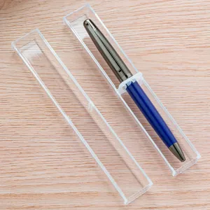 Klare Plastik Stiftbox mit blauem Kugelschreiber auf Holzgrund, minimalistisches Etui.