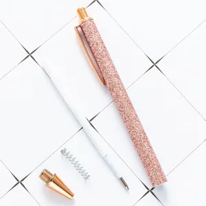 Rose gold glitter retractable ballpoint pen disassembly view on white grid background