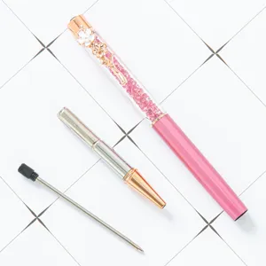 Elegant pink crystal ballpoint pen with rose gold clover clip and glittering rhinestone decor.