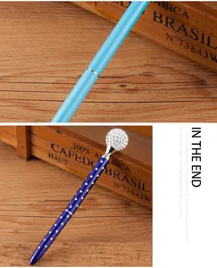 Detailed view of a luxury metal ballpoint pen featuring a sparkling rhinestone crystal ball top.