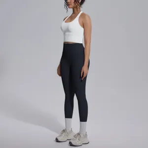 Close-up detail van de sportieve yogaset met witte crop top en zwarte leggings met hoge taille.