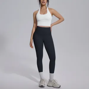 Details van de witte halter crop top en zwarte hoge taille leggings voor fitness.