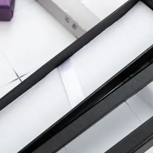 Caja de regalo larga negra para boligrafo con forro interior blanco y cinta de sujecion.