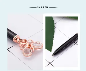 Detailed shot of metal ballpoint pen with crystal butterfly top and smooth black barrel.