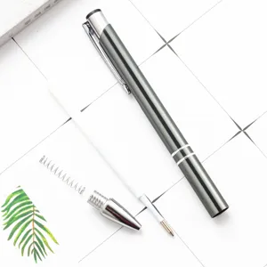 Metal ballpoint pen set disassembled flat lay on grid background for office and school.