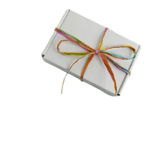 Scatola regalo bianca con nastro in raffia arcobaleno colorato per confezioni artigianali e decoro.