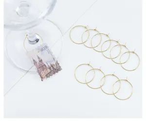 Vue détaillée des anneaux de breloques pour verres à vin DIY dorés avec pendentif rétro.