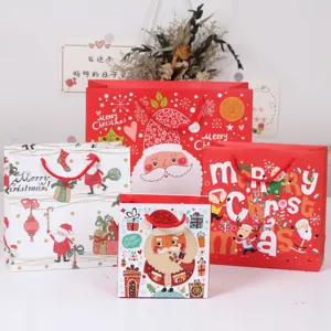 Sacchetti regalo in carta di Natale con simpatici disegni di Babbo Natale e renne per feste.