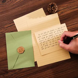 Set di cancelleria in carta kraft vintage con busta verde, carta a righe e sigillo di cera.