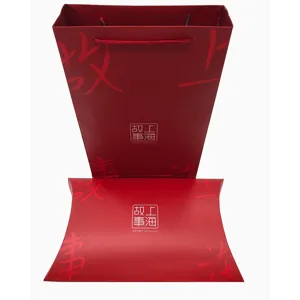 Vista detallada de la elegante bolsa de regalo de papel rojo y caja de almohada, embalaje.