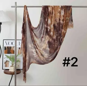 Detail view of a brown tie-dye pleated scarf hanging on a rack with a stylish background.