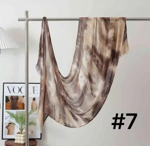 Detailed view of women soft modal tie dye gradient scarf hanging on metal rack indoor display.