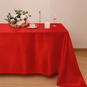 Vista dettagliata di tovaglia in raso rosso liscio su tavolo da banchetto con elegante decoro.