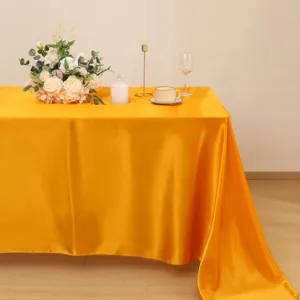 Vista dettagliata della tovaglia in raso giallo con consistenza liscia e drappeggio.