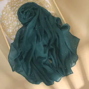 Detailed view of the dark green sequin shawl, showcasing soft fabric and sparkling accents.