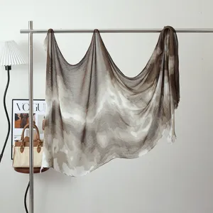 Detailed view of ink wash gradient modal shawl hanging on a metal rack with stylish decor.