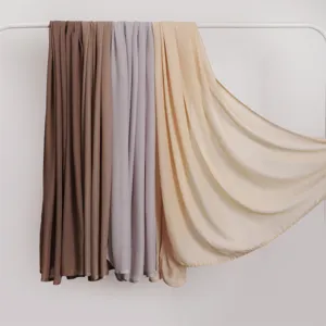 Detail view of soft modal cotton long shawl scarf hanging on rack in multiple solid colors.