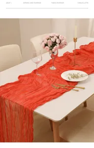 Détail du chemin de table en gaze rouge translucide pour une décoration de table élégante.