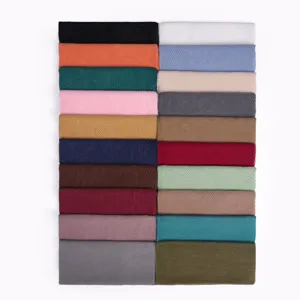 Detailed view of multiple solid color pleated scarves, showing fine texture and colors.