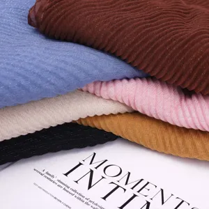 Close-up details of pleated metallic thread scarves showing fine texture and soft fabric layers.