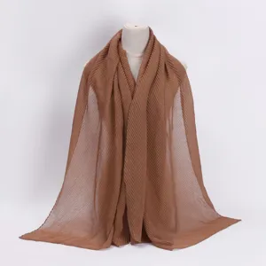 Details of the brown pleated scarf showing the exquisite crinkle texture and elegant drape.