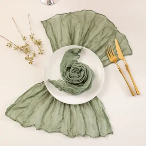 Green gauze table runner detail, boho pleated wedding party table decor fabric for dining setup.