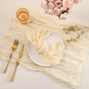 Detailed view of bohemian cheesecloth table runner and napkin set in elegant champagne.