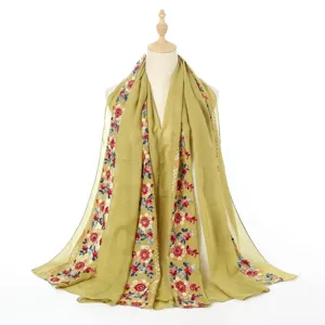 Detailed view of the embroidered cotton linen shawl, showing delicate floral pattern.
