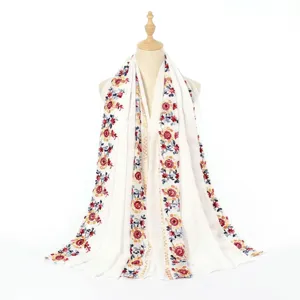 Detailed view of white cotton linen floral embroidered ethnic shawl scarf for travel.