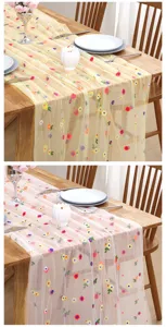 Detailed view of the sheer mesh table runner with colorful floral embroidery for dining decor.
