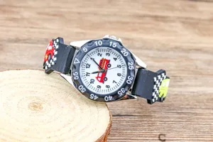 Nahaufnahme der Kinderuhr mit Auto- und Feuerwehrauto-Muster auf Zifferblatt und Armband.