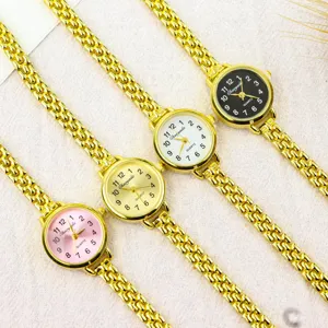 Close up of dainty gold chain quartz watch with small dial, delicate metal strap and dial.
