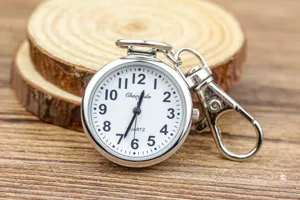 Vue détaillée de la montre de poche à quartz argentée avec cadran et mousqueton en métal.